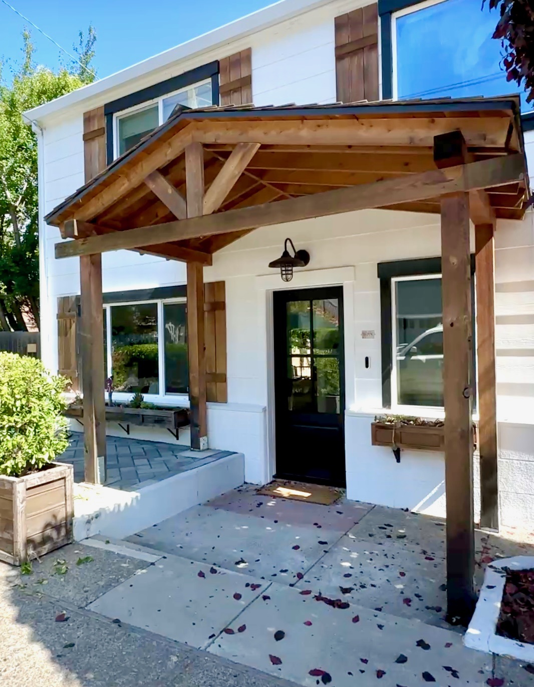 Residential entry with wood detailing and a sheltered front porch